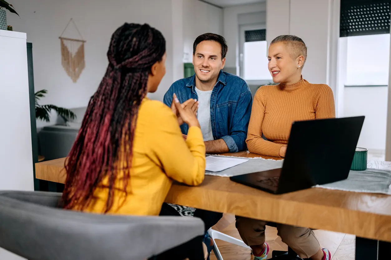agent talking to a couple with laptop open