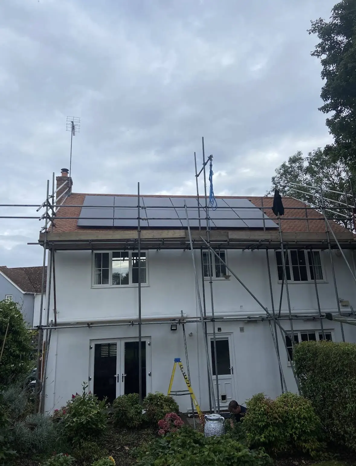 a house with scaffolding and solar panels on the roof