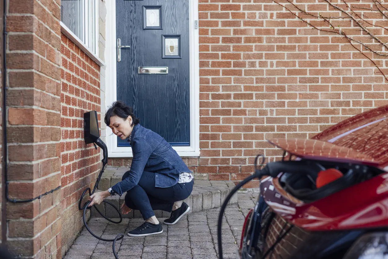 man plugging in electric charger
